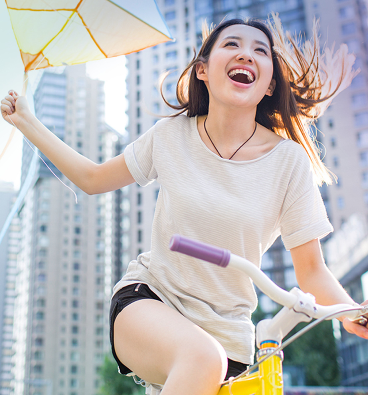 Girl holding a kite on a bike